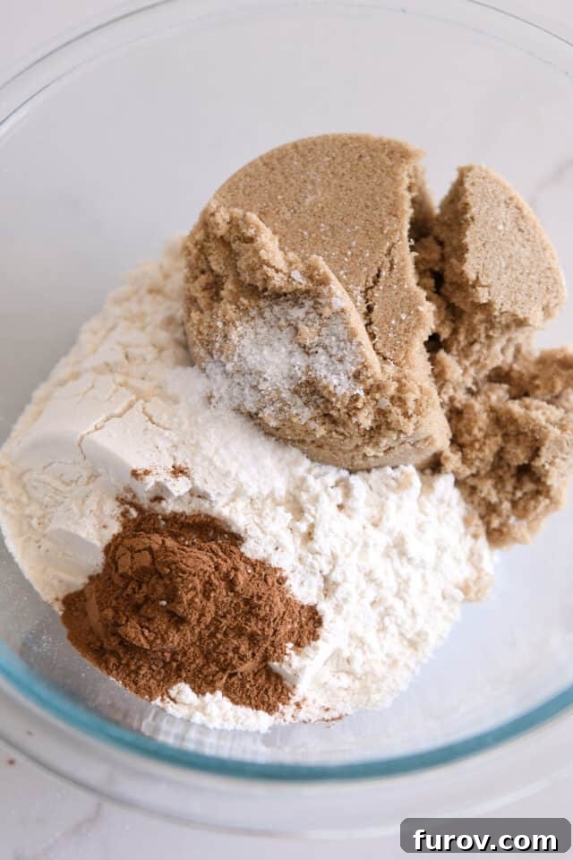 Brown sugar, flour, salt, and cinnamon in a glass bowl, ready to be combined for the streusel.