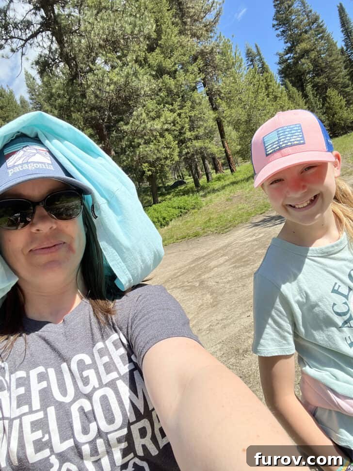 A heartwarming selfie of a mother and daughter enjoying their time together outdoors, possibly during a camping trip or family outing.