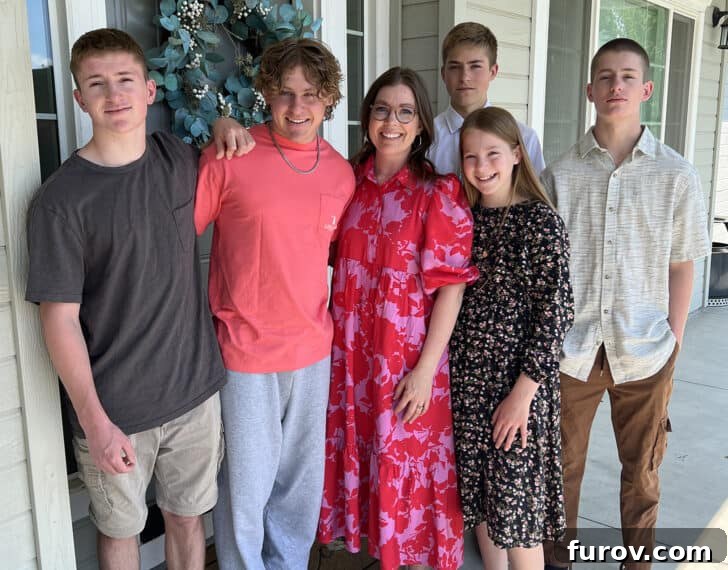 A loving photo of a mother with her five children, capturing a beautiful family moment outdoors.