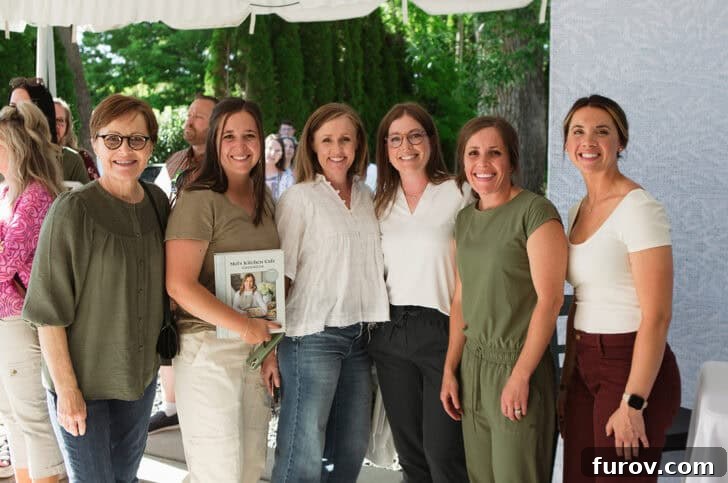 Mel, the cookbook author, engaging with enthusiastic guests and signing books at her vibrant launch party.