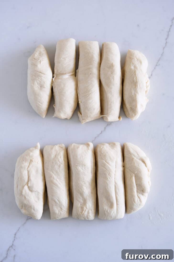 Two pieces of bread dough cut into five thick strips each, ready for dipping.