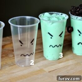A vibrant green monster pudding cup topped with crushed chocolate cookies.