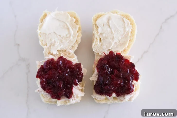The Ultimate Leftover Turkey Sandwich: Restaurant Favorite At Home 6 Two rolls open, spread with mayo, and shredded turkey and cranberry sauce on bottom halves.