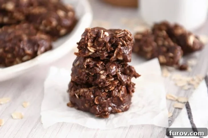 Irresistible No-Bake Chocolate Cookies 3 Three perfectly stacked chocolate no-bake cookies on parchment paper, ready to be enjoyed.