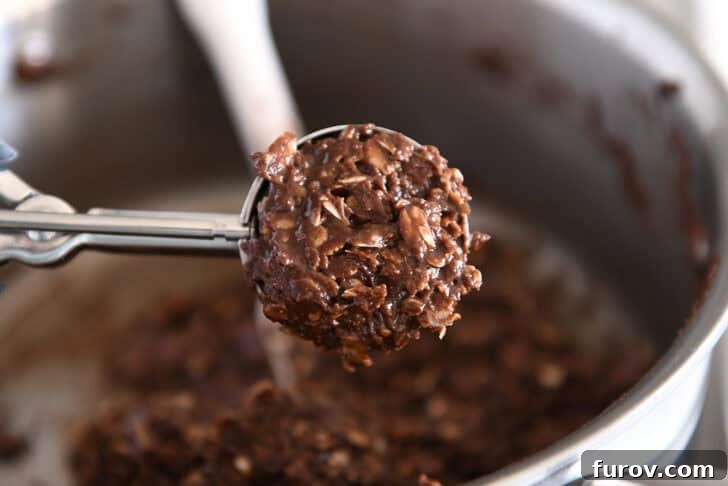 Irresistible No-Bake Chocolate Cookies 8 Cookie scoop precisely portioning chocolate no-bake cookie batter onto a parchment-lined baking sheet.