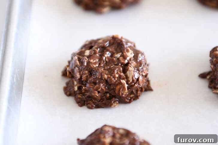 Irresistible No-Bake Chocolate Cookies 9 Perfectly flattened mound of chocolate no-bake cookie dough on a parchment-lined baking sheet, ready for chilling.