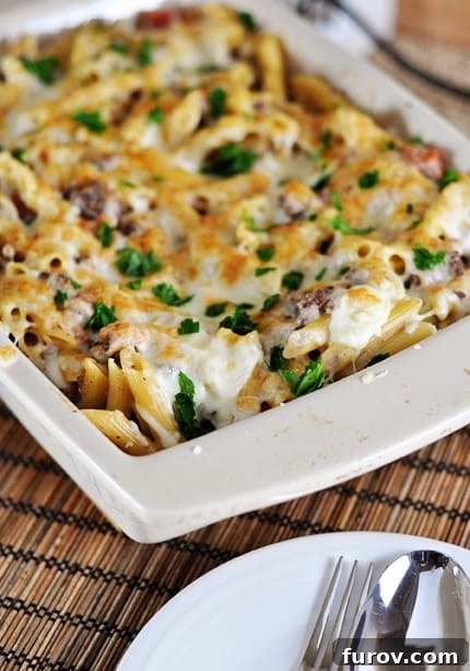 White casserole dish with a baked, cheese-topped, Greek Pastitsio pasta.