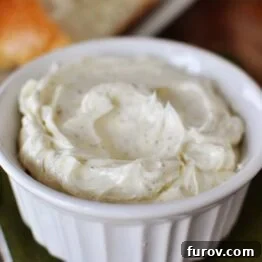 A small bowl of homemade garlic and herb butter spread.