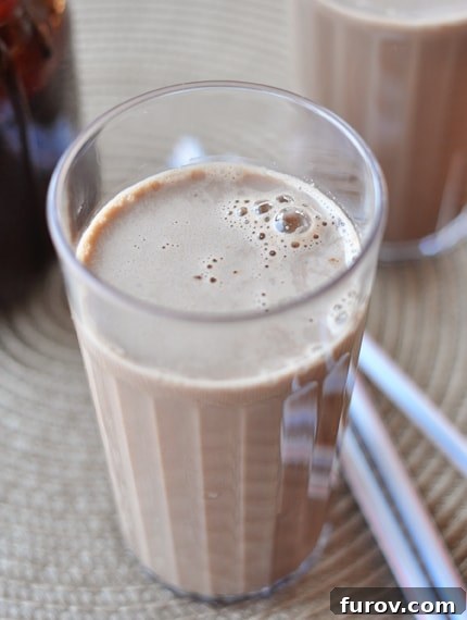 A tall glass of rich homemade chocolate milk, invitingly placed to showcase its creamy texture and deep chocolate hue.
