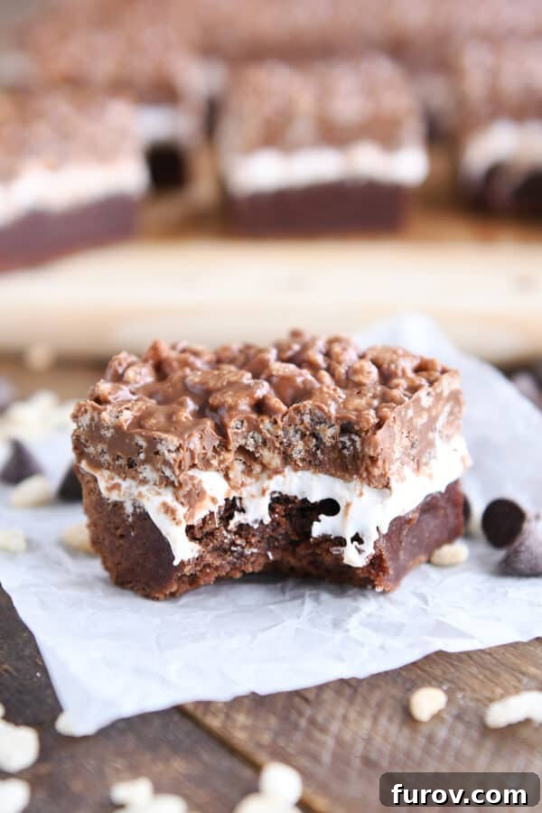 Killer crunch brownie on white paper with bite taken out, showcasing the distinct layers.