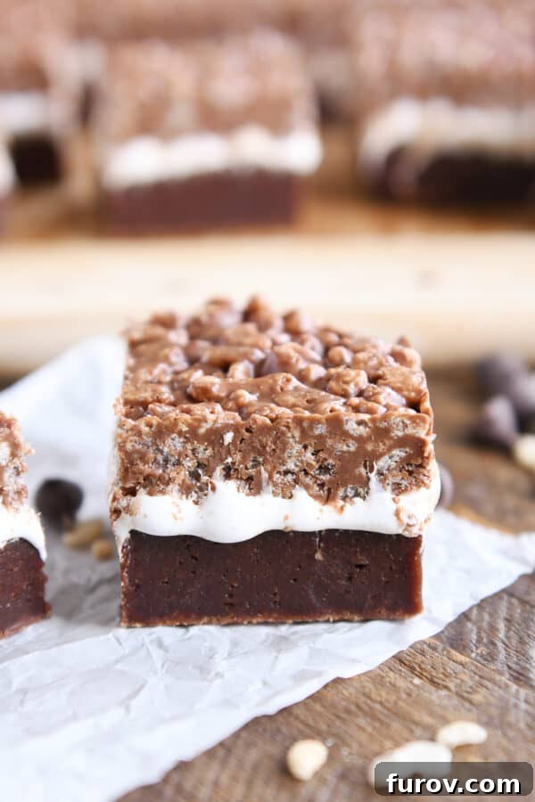 A single Killer Crunch Brownie square resting on a piece of white parchment paper, highlighting its layers.