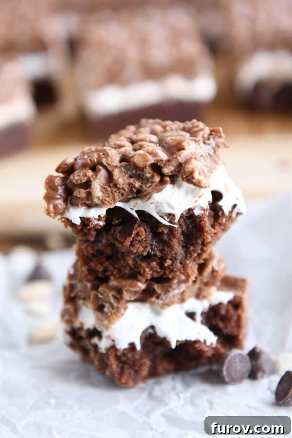 A Killer Crunch Brownie broken in half and stacked, revealing the distinct layers of brownie, marshmallow, and crispy topping.