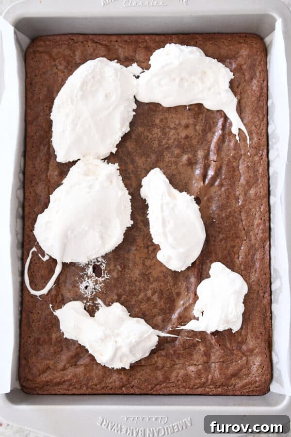 Marshmallow cream dolloped generously over the top of a warm pan of freshly baked brownies.