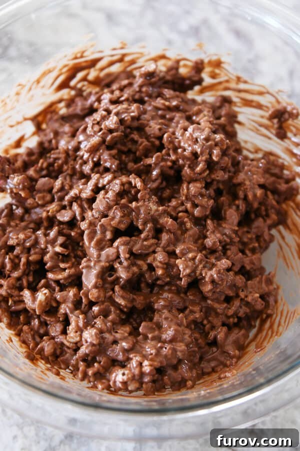 A close-up of the peanut butter, chocolate, and crisp rice cereal mixture in a glass bowl, ready for spreading.
