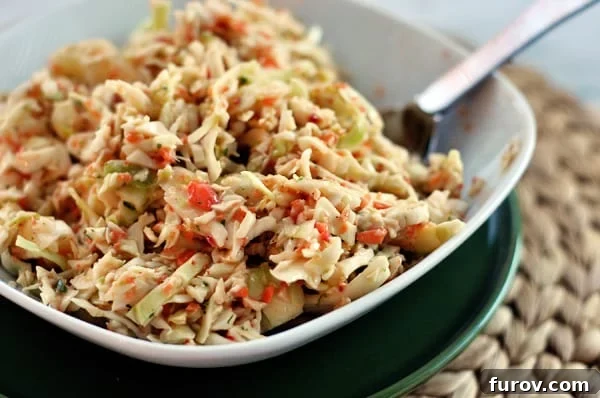 Homestyle Coleslaw 2 A beautifully presented white dish full of fresh, vibrant coleslaw, ready to be served.