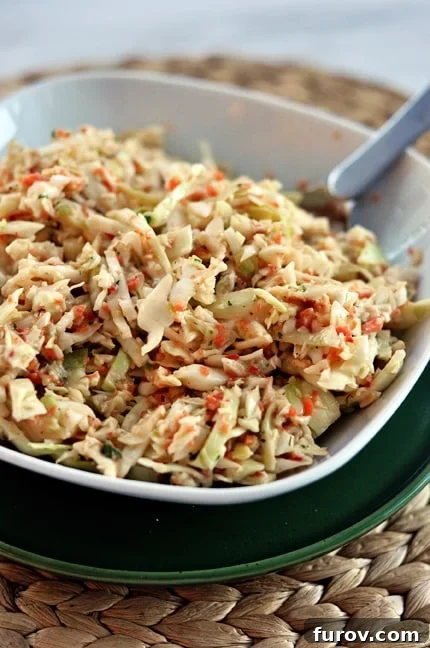 Homestyle Coleslaw 3 A close-up, top view of a white dish brimming with the vibrant, creamy coleslaw, showcasing its texture.