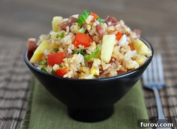 Delicious Hawaiian Fried Rice in a Black Bowl with Pineapple and Ham