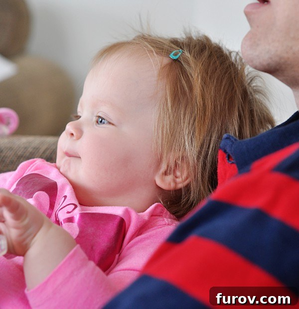 A little girl with her hair neatly styled with a clip, looking happy and tidy.