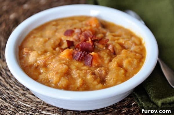 Hearty Slow Cooker Ham Sweet Potato White Bean Soup with Crispy Bacon 3 White bowl with ham, sweet potato, bacon, and white bean soup.