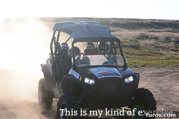 A vibrant off-road vehicle (RZR) with two people in a dynamic outdoor setting, perhaps mid-adventure.