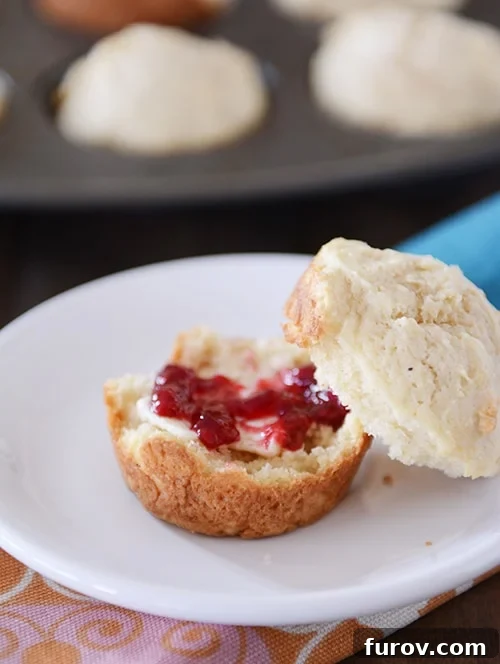 A sour cream muffin split in half with jam and butter in the middle. 