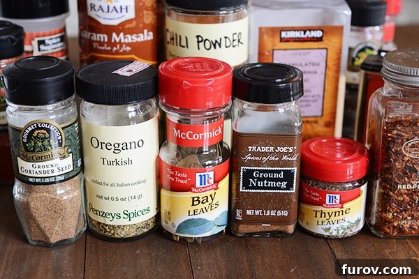 Various baking spices in small jars and containers, including cinnamon sticks, star anise, and whole cloves.