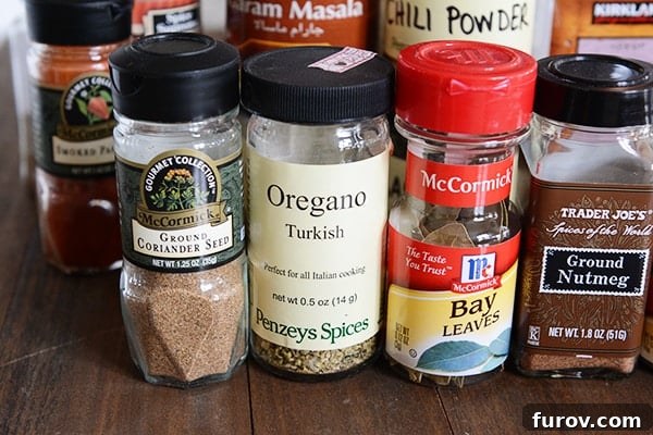 A vibrant assortment of whole and ground spices displayed on a rustic wooden surface.