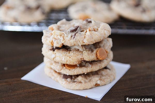 A stack of four perfectly baked 7-Layer cookies, showcasing their golden-brown color and visible chips.