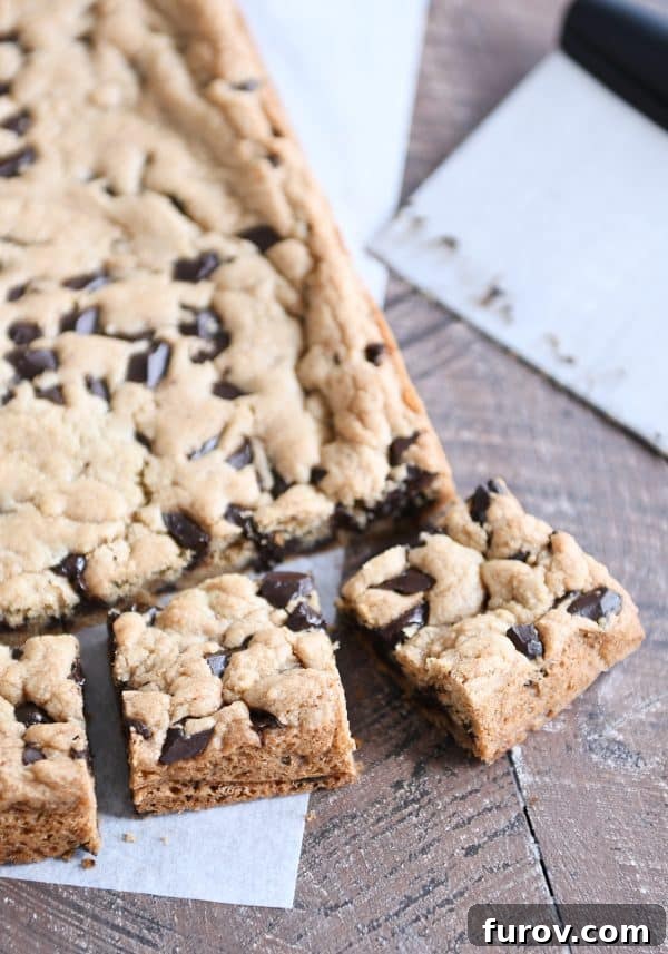 A golden slab of baked chocolate chip cookie bars, freshly cut into perfect squares.