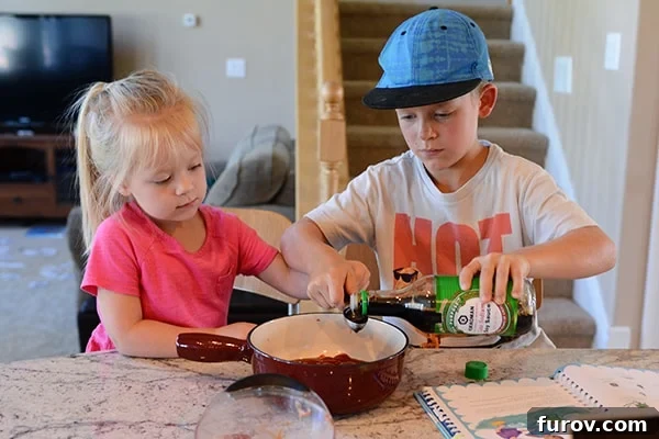 Snapshot Saturday: Mastering Mealtime Mayhem 5 A young boy and a little girl cheerfully cooking together in a kitchen, a scene of heartwarming teamwork.