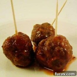 Saucy Meatballs on a white plate with toothpicks.