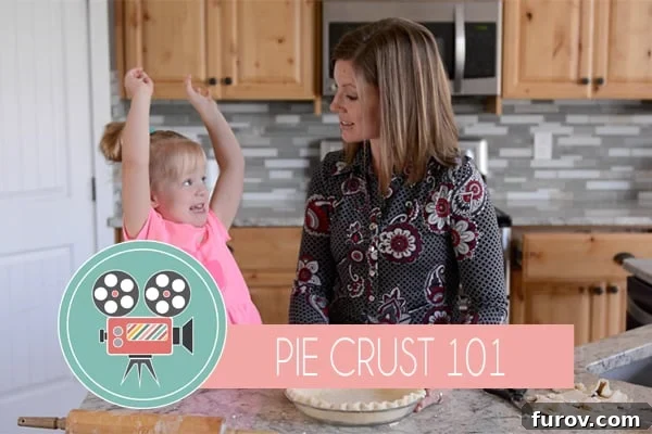 The Ultimate Guide to Flawless Pie Crust 2 A mom and her little girl happily baking a homemade pie crust together in a kitchen, demonstrating the joy of family cooking.