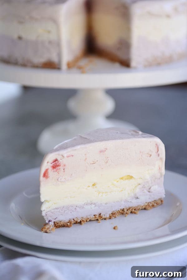 A slice of layered ice cream cake with a sugar cone crust on a white plate.