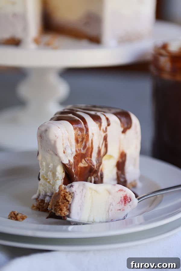 A slice of ice cream cake with a bite taken out on a white plate.