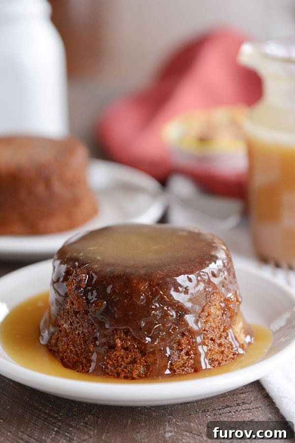 A small, brown cake covered in a light brown sticky toffee sauce.