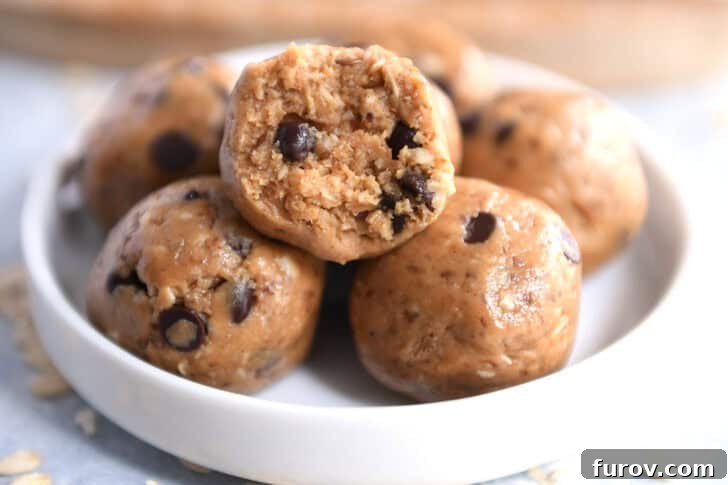Close-up of soft peanut butter chocolate chip protein bites in a small white dish, with one bite taken out.