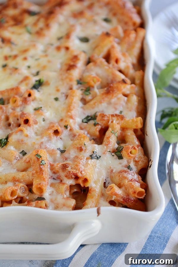 Dondurucu Dostu Fırında Peynirli Ziti 4 A white casserole dish full of cheese-topped baked ziti sprinkled with cilantro.