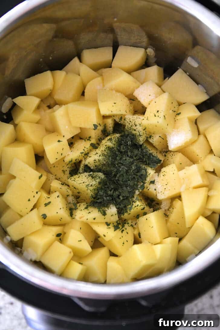 Diced potatoes, salt, dried parsley, and water ready for pressure cooking in an Instant Pot.