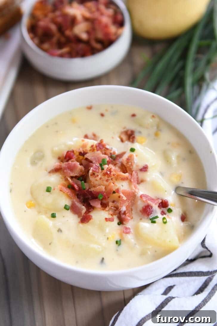 A pristine white bowl filled with creamy Instant Pot potato soup, generously topped with crispy bacon bits.