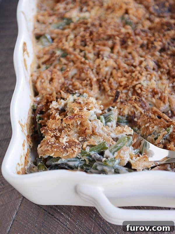 Top view of a white casserole dish of crunchy-topped homemade green bean casserole, ready to serve.
