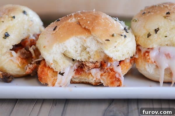 A single pull-apart pizza slider with a bite taken out, showing the melted cheese and pepperoni inside.