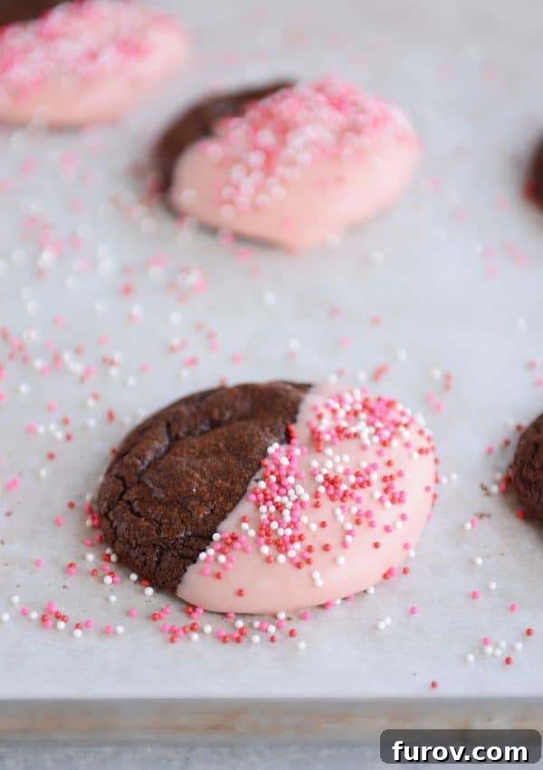 Decadent One-Bowl Fudgy Brownie Cookies 3 Chocolate brownie cookies half-dipped in white frosting and colorful sprinkles, arranged artfully.