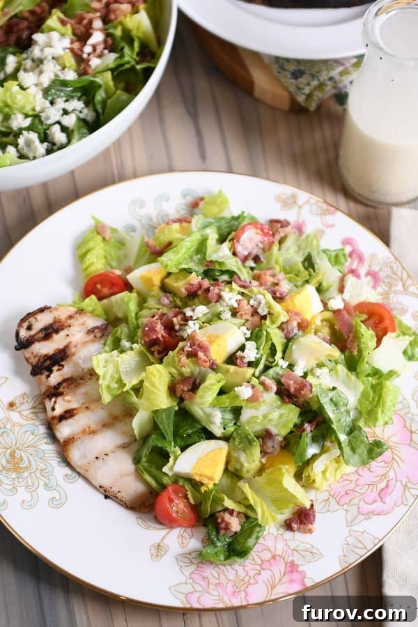 Chargrilled Chicken Cobb Salad 2 Grilled chicken cobb salad on white plate with pink flowers, highlighting the rich colors and textures.