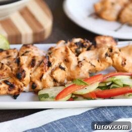 Cucumber salad with almond coconut milk chicken satay on white platter.