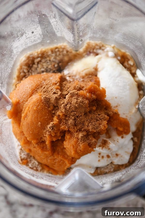 Effortless Gluten Free Pumpkin Chocolate Chip Blender Muffins 3 Ingredients for easy pumpkin blender muffins layered in a Vitamix blender, ready to be processed.