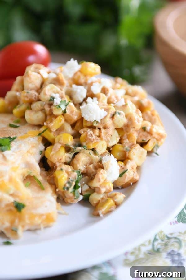 Zesty Mexican Street Corn Salad 3 A scoop of creamy Mexican street corn salad served on a white plate alongside cheesy quesadillas, perfect for a casual meal.