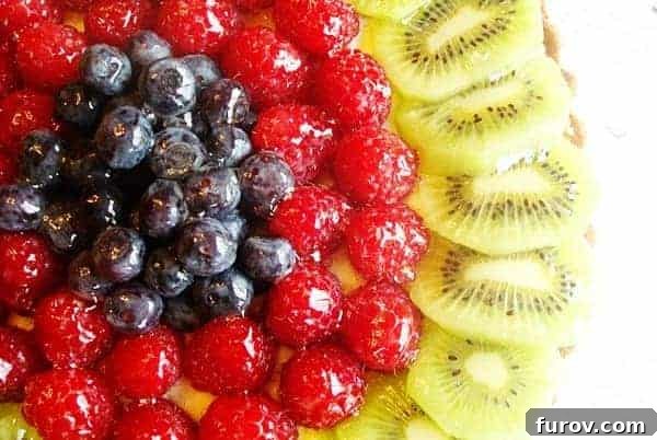 Elegant Fresh Fruit Tart 2 A vibrant Classic Fresh Fruit Tart adorned with fresh blueberries, raspberries, and kiwi slices.