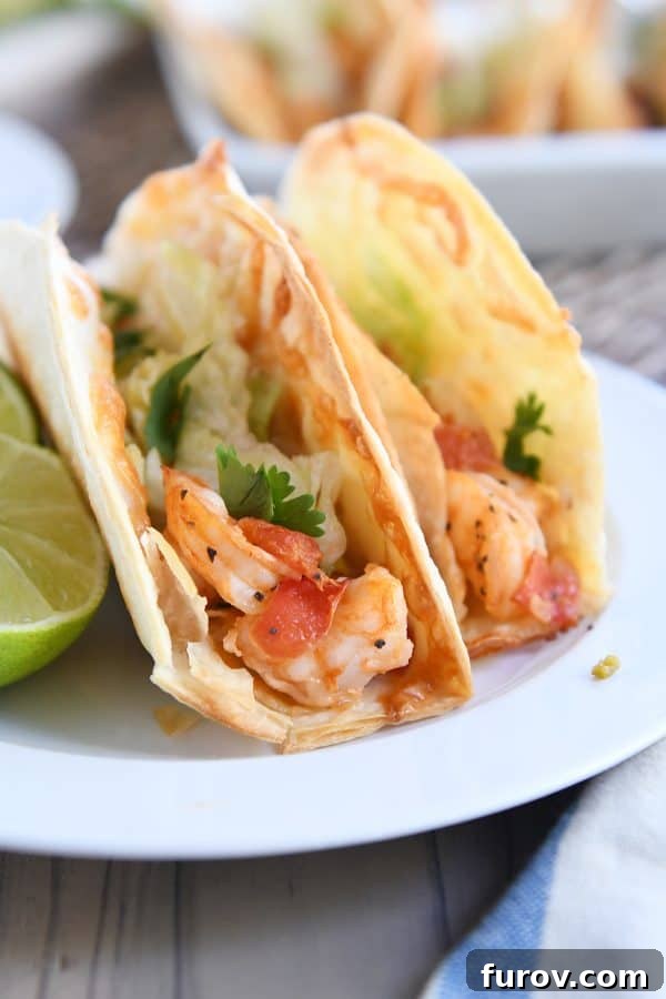 Golden Crunch Shrimp Tacos 3 Two golden-brown crispy shrimp tacos, filled with a savory shrimp mixture, presented on a simple white plate.