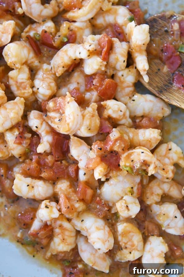 Golden Crunch Shrimp Tacos 6 Juicy shrimp and the rich, savory tomato mixture for tacos, simmering together in a cast iron skillet on the stovetop, developing deep flavors.
