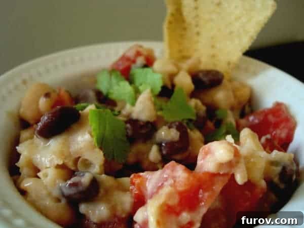 Bowl of black and white bean dip with chip.
